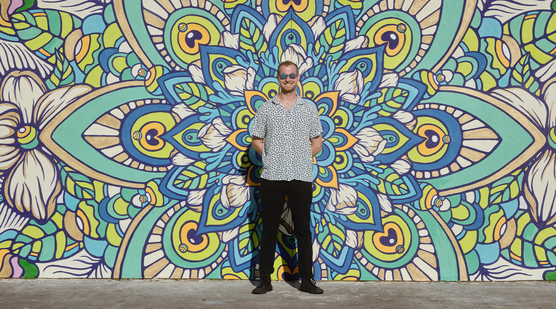 Harry Foreman of Akyros Inc. Stands in front of the mural he painted for Ruth's Chris Restaurant In Winter Park Village