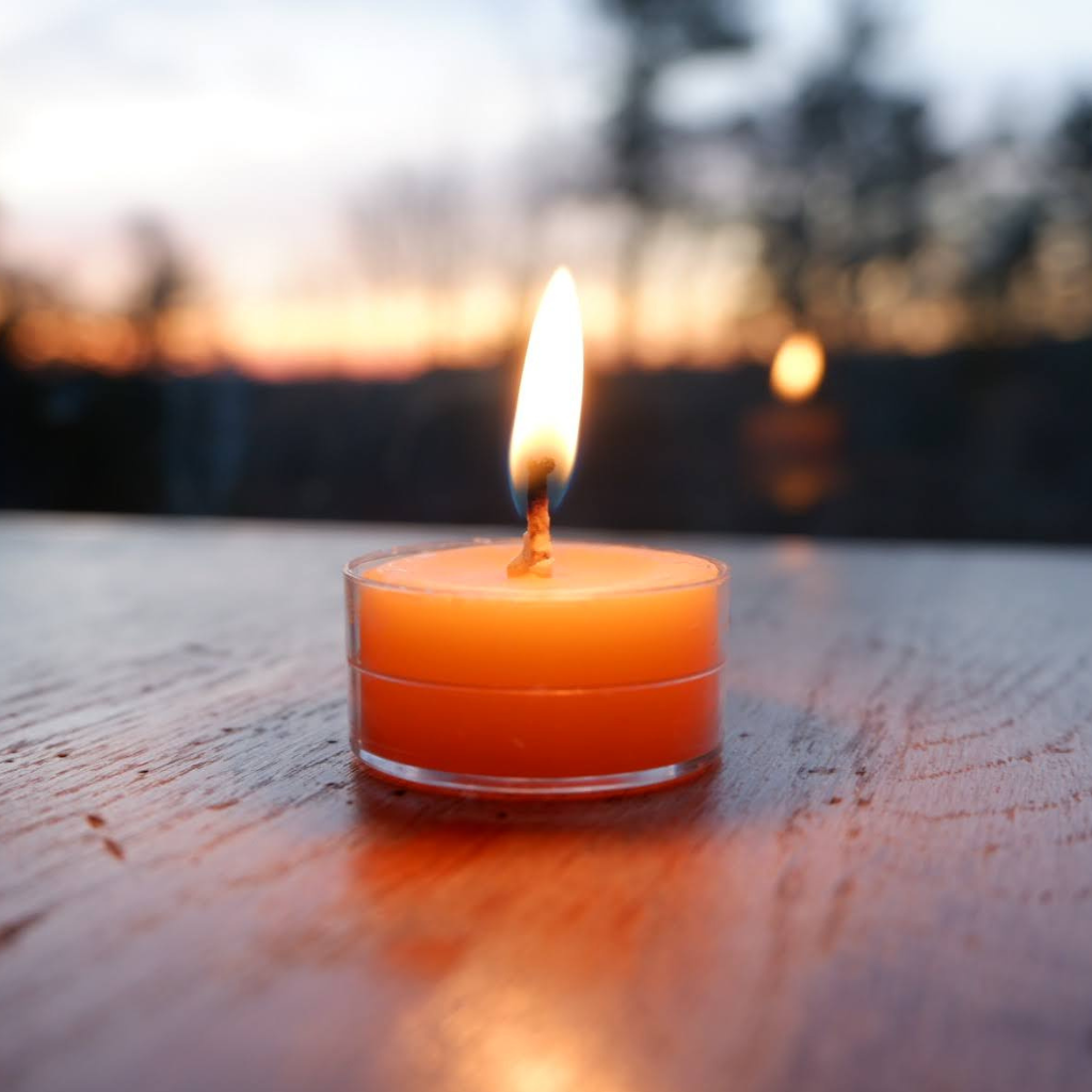 Lit tea candles and candles with copy space on black background Stock Photo  by Wavebreakmedia