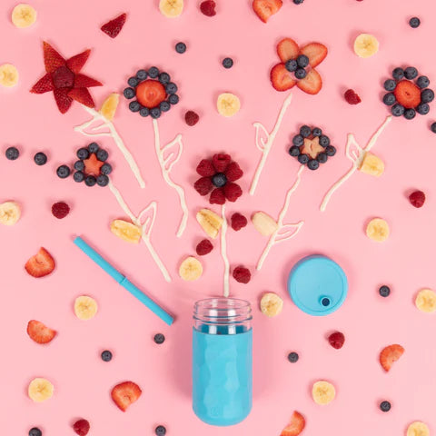 Blue Glass Drinking Jar on Pink Background with fruit coming out