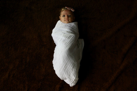 holding baby wrapped in blanket