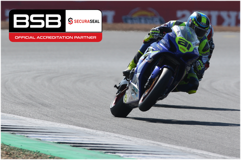 Motorbike racer going around track with company logo