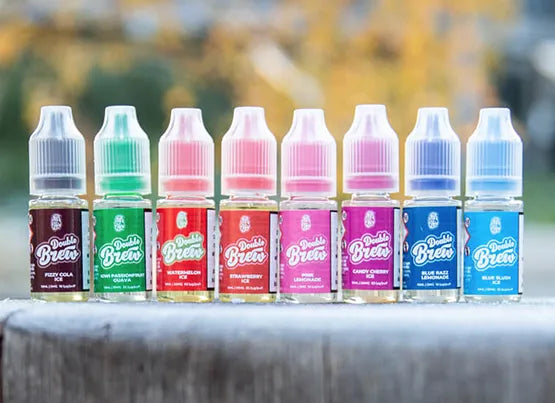 Eight 10ml Double Brew Bar Series e-liquid bottles stood in a row on a wooden tree stump.