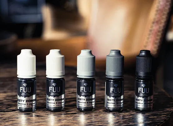 Five Fuu Original Silver e-liquid bottles stood in a row on a wooden table.