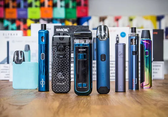 A selection of different vaping kits on a wooden table.