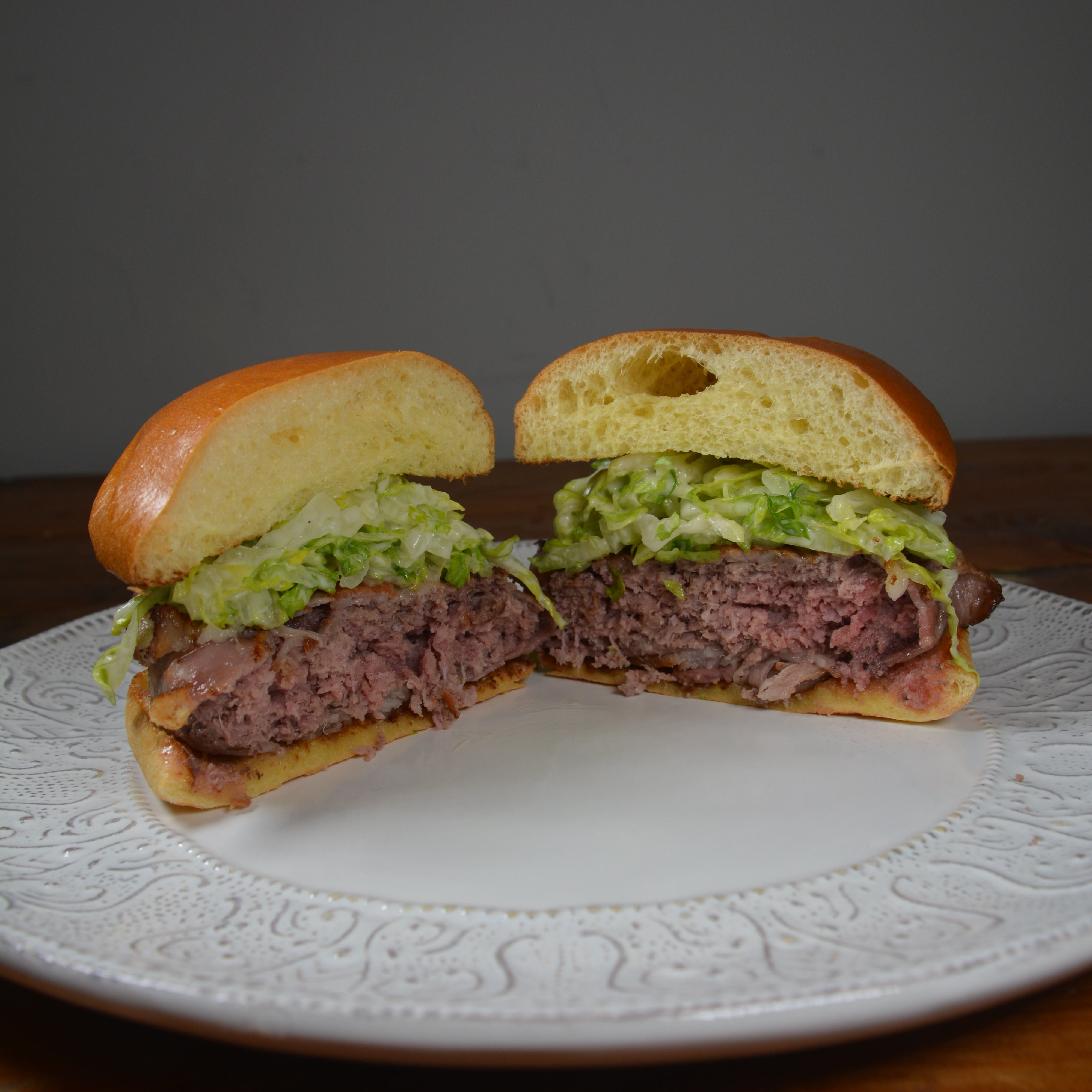 bacon wrapped bison burger cooked perfectly on cinder grill reverse sear method