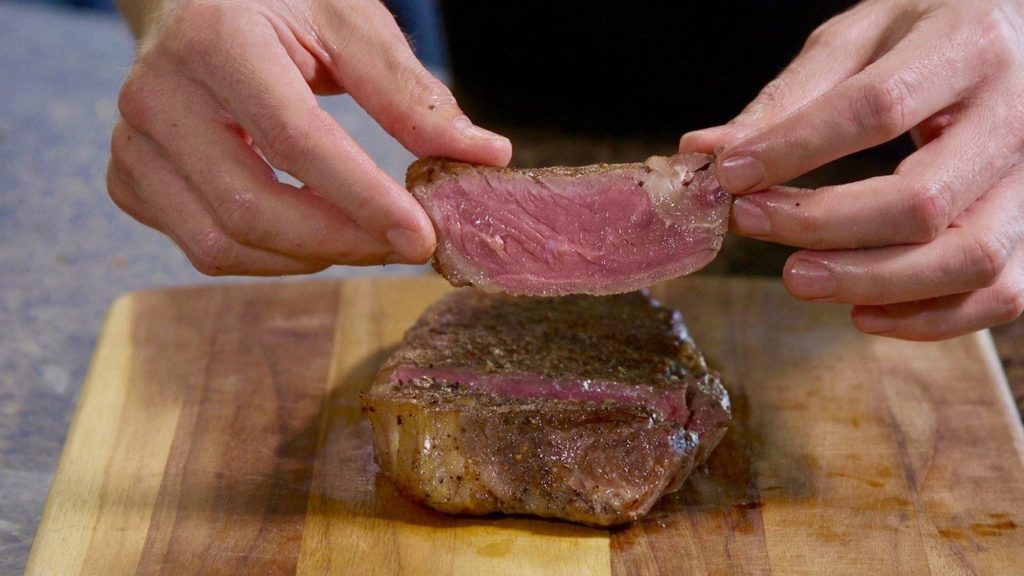 perfectly cooked new york strip on cinder grill