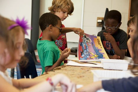 Motivated child helping another child at school