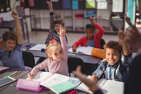 Young students being respectful and raising their hands