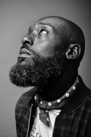 A black and white photo of a black bearded man looking up