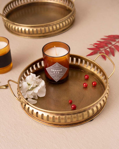 Elegant golden brass serving tray showcasing a timeless design, with candles , suitable for an upscale home aesthetic.
