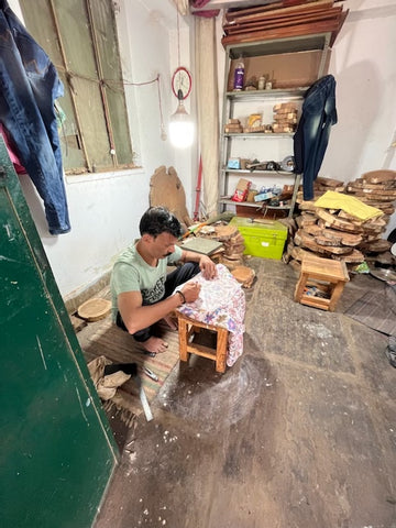 An artisan in India hand carving a block 