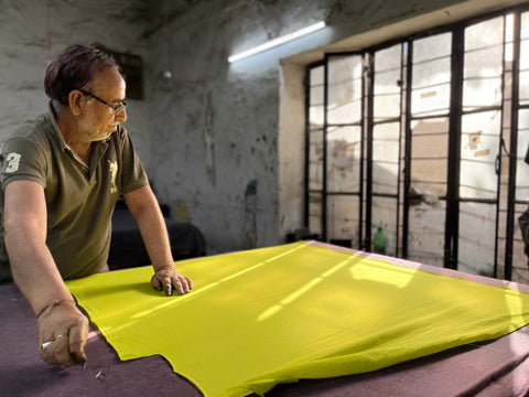 Indian artisan stretching textile on table for hand block printing