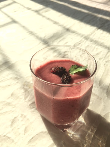 Smoothie with frozen banana, strawberry, mulberry and celery