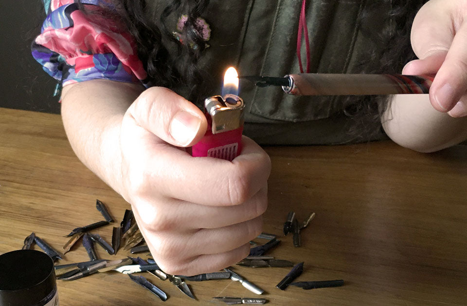 Passing a nib through a flame to remove the coating