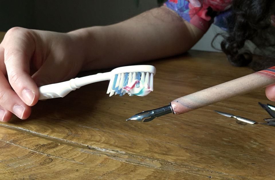 Brushing a new nib with toothpaste to remove the coating