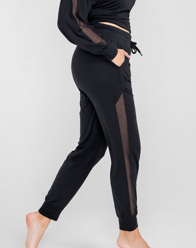 Model Raine wearing BlissWear Jogger in size Medium and color Midnight, seen from the Side