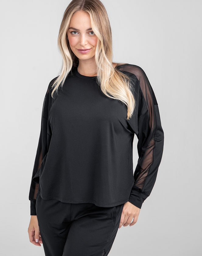 Model Raine wearing blisswear-long-sleeve-top in size Medium and color Midnight, seen from the Front