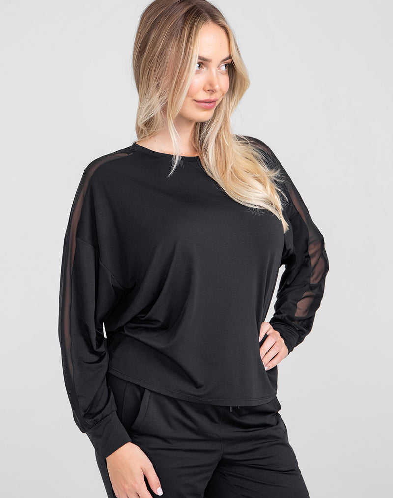 Model Raine wearing BlissWear Long Sleeve Top in size Medium and color Midnight, seen from the Side