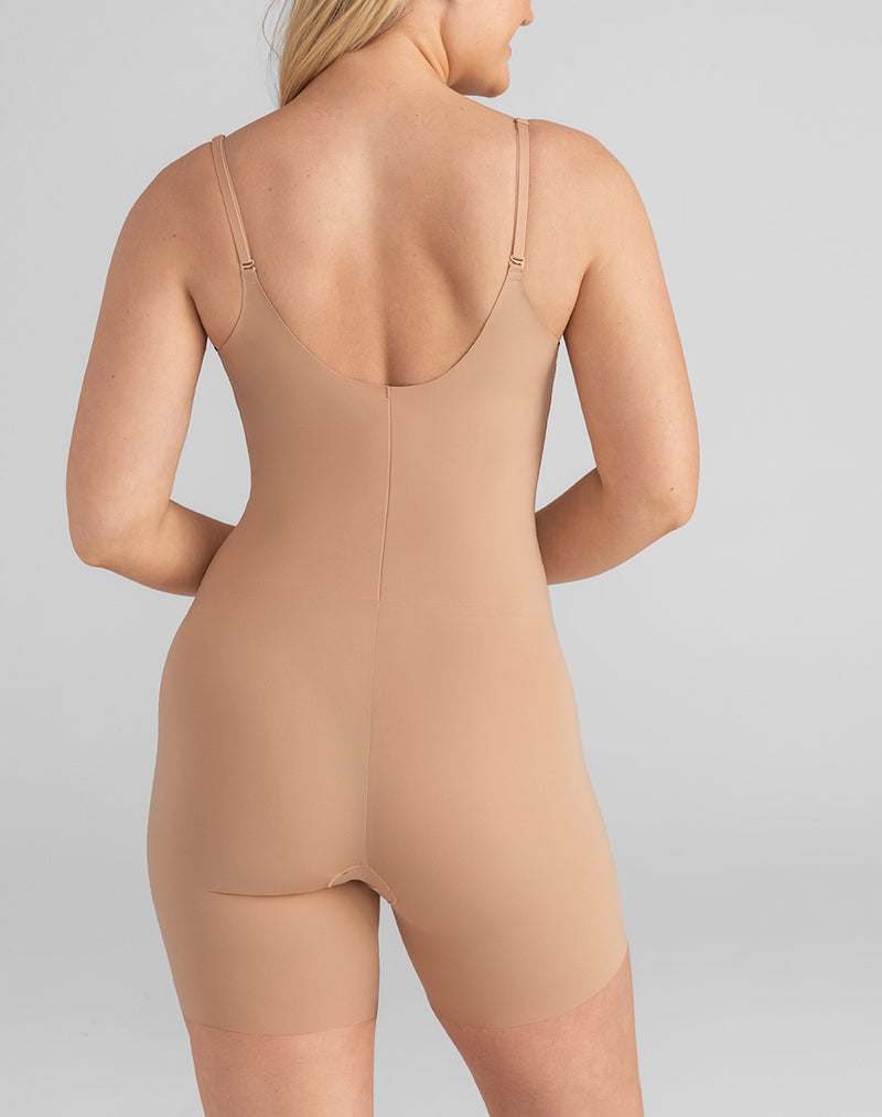 Model McCallah wearing Open-Bust Mid-Thigh Bodysuit in size Large and color Sand, seen from the Back