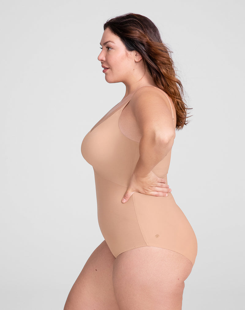 Model Natalie wearing Cami Bodysuit in size Plus size one and color Sand, seen from the Side
