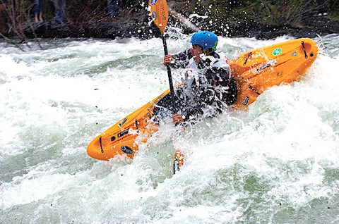 A kayaker runs the Wild Mile of the Swan River in the Bigfork Whitewater Festival. Photo by David Reese/Montana Living