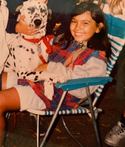 Axiology founder, Ericka Rodriguez, has always loved animals, poses with dog as a kid