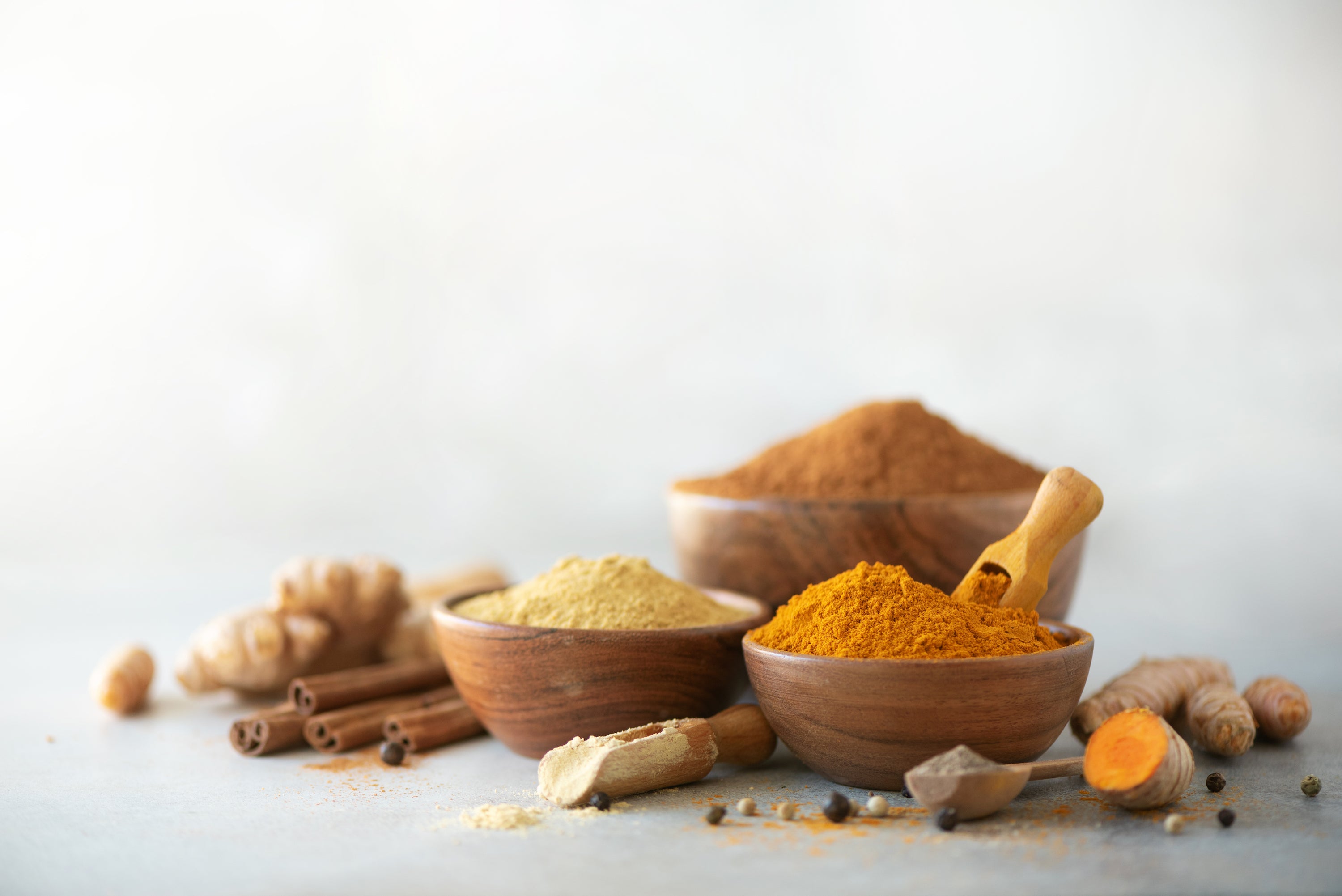 ginger and turmeric ground in bowls with roots on table