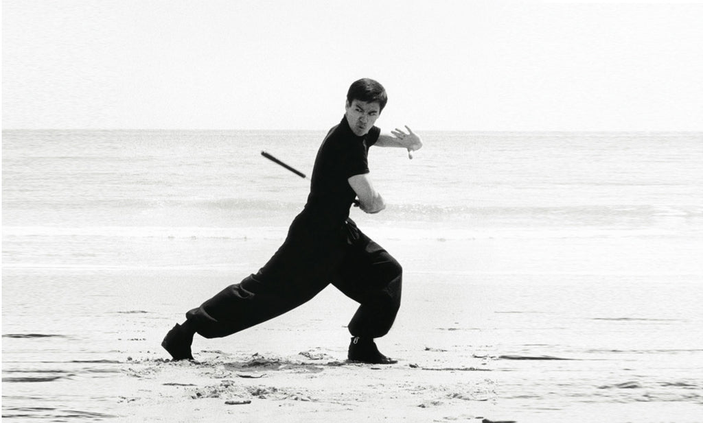 Bruce Lee practicing on beach in all black
