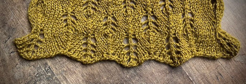 lace edge of Marigold, a lace shawl knit in June Cashmere, showing that how a loose bind-off method allows the lacework to bloom