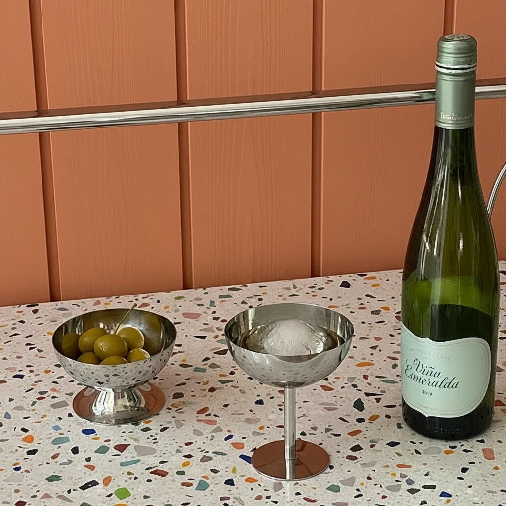 Bottle of Vina Esmeralda wine with two metal bowls on a white surface.