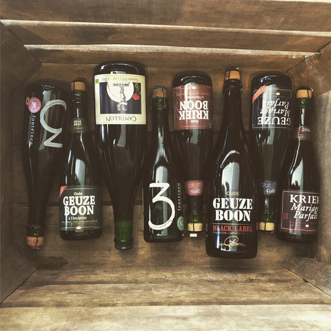 Image showing 8 bottles of lambic beers lying in a wooden crate.