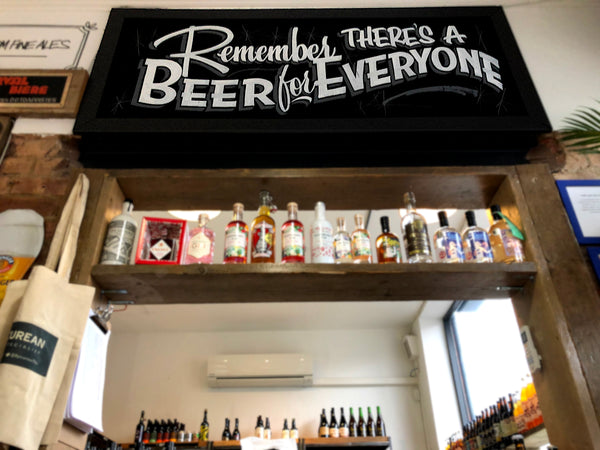 Photograph showing a hand-written chalk sign that reads 'Remember, there's a beer for everyone'.