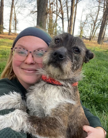 Blonde woman with scruffy dog wearing a pirates and sea creatures junk headband outside