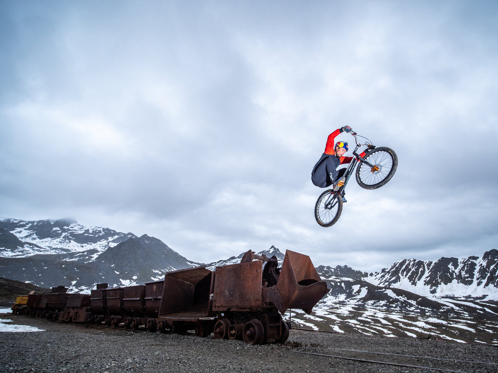 Kenny Belaey, Red Bull athlete and JUNK Brands lover, catching some sweet air in the mountains in front of an industrial train