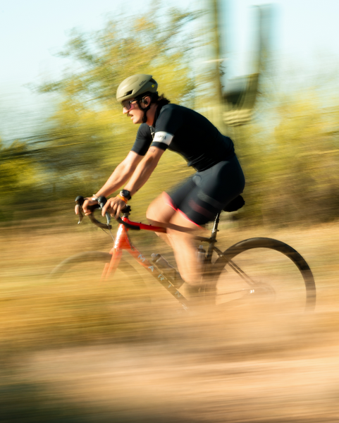 A bicyclist, Patrick MacDonald, rides his bike. The image shows the brown and green scenery speeding by him.