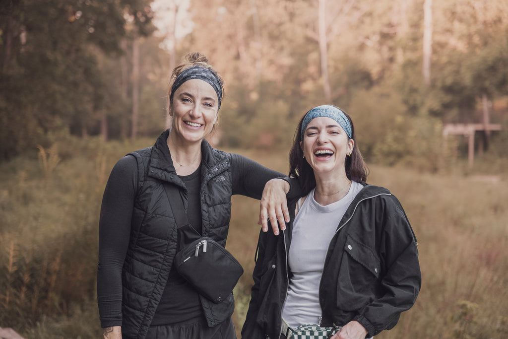 Two women smiling at the camera in their junk headbands and fall outfits in the wilderness in the fall, fall headbands, fall activity headbands