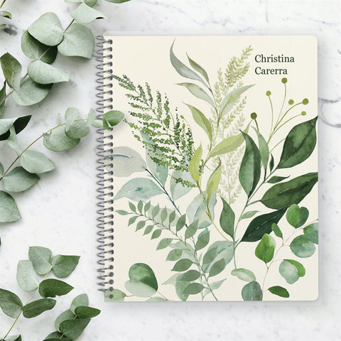 planner with leaves on the cover on a table with eucalyptus
