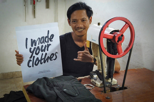 Psylo team member holding Fashion Revolution's I Made Your Clothing campaign sign