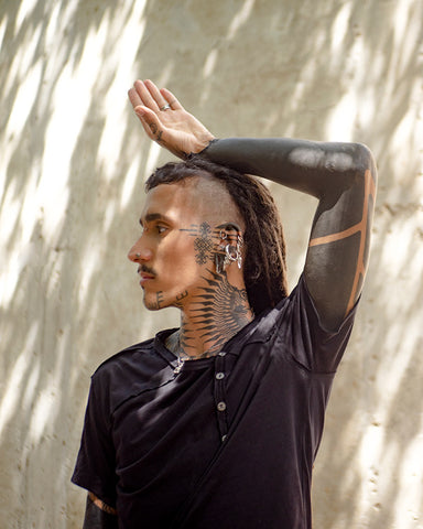 Tribal tattooed man wearing Psylo Off Tee
