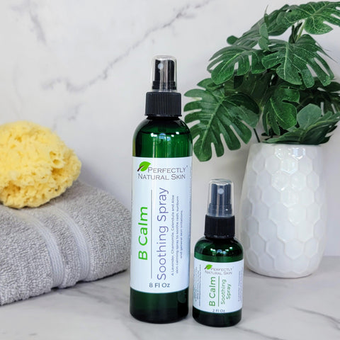 2 sizes of B Calm Bottles next to towel, greenery and a sponge