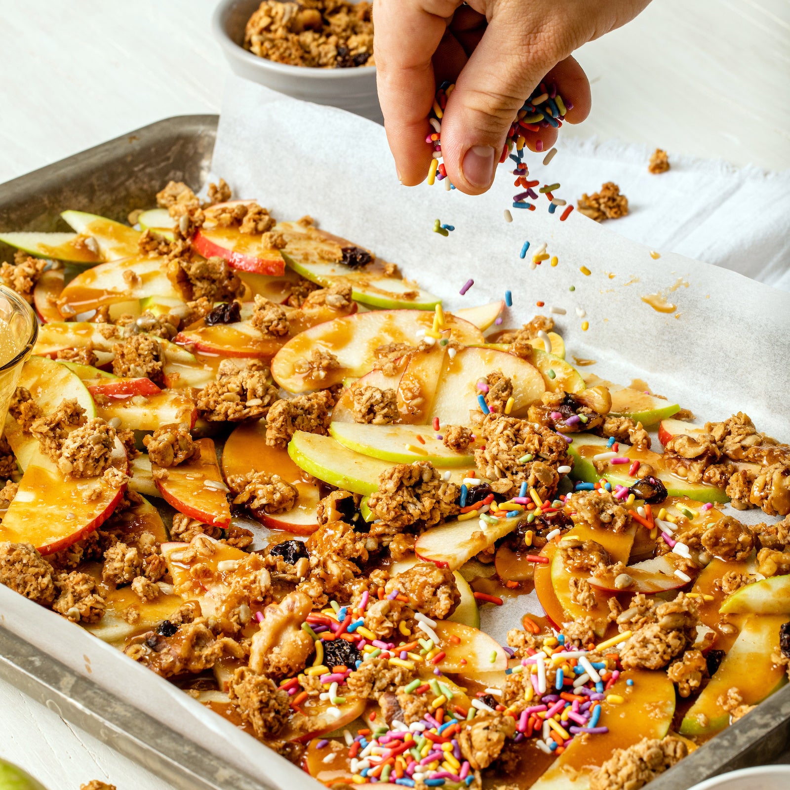 Tray of baked apples slices with Almond Butter granola sprinkled on top.