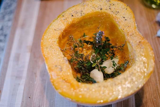 pumpkin half with garlic cloves and fresh thyme