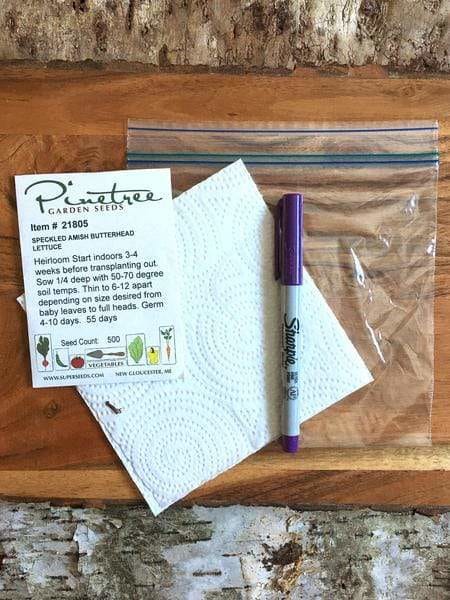 Seed packet, marker, napkin, and plastic back on a table