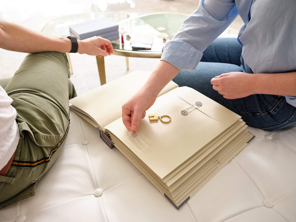 Two people putting a label on a slate folio