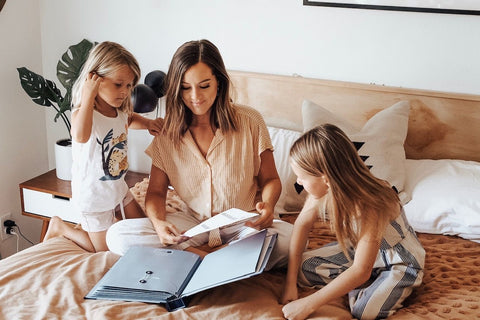 mom and girls with savor folio on bed
