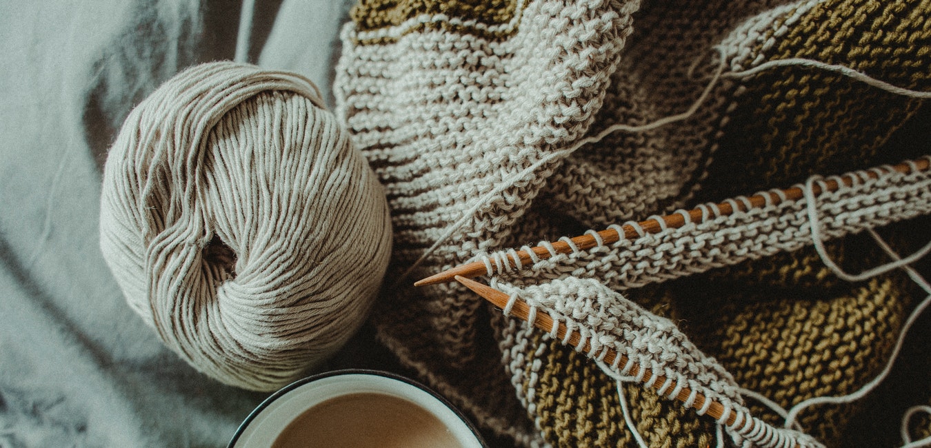 Wollknäuel und Kaffee mit Nadeln