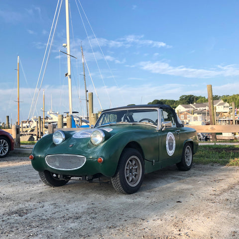 Austin Healy Sprite in front of boats