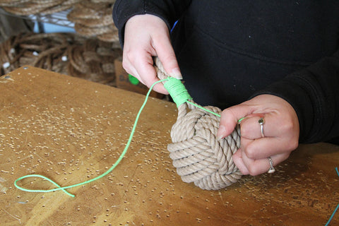 tightening the finishing whip on a dog toy
