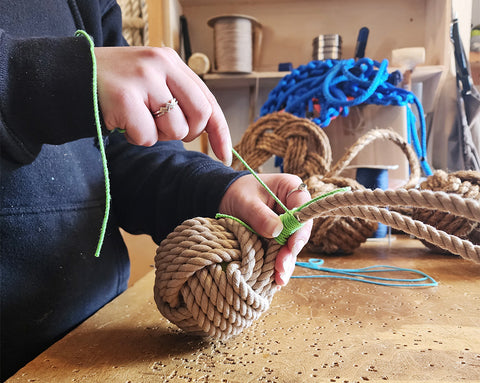 whipping a tan dog toy in the Mystic Knotwork workshop