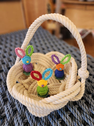 a rrope basket full of colorful macrame bunnies